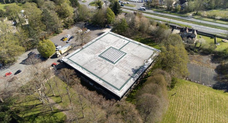 Aerial view of a building showcasing its roof and surrounding area, highlighting architectural features and layout.