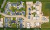Aerial view showcasing a modern residential development with neatly arranged homes and green spaces.
